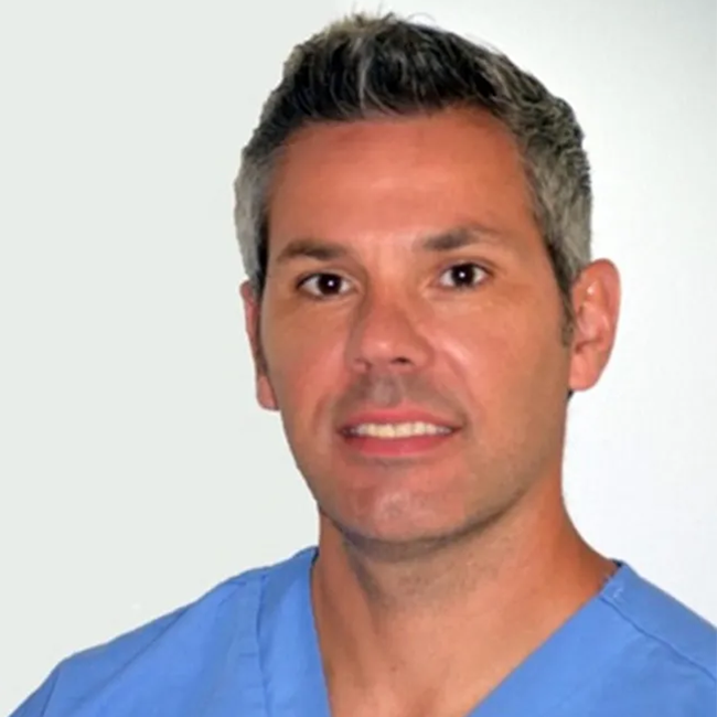 Portrait of Dr. Fernando Garcia-Pereira, a veterinary anesthesiologist wearing blue scrubs - pet urgent response and emergency
