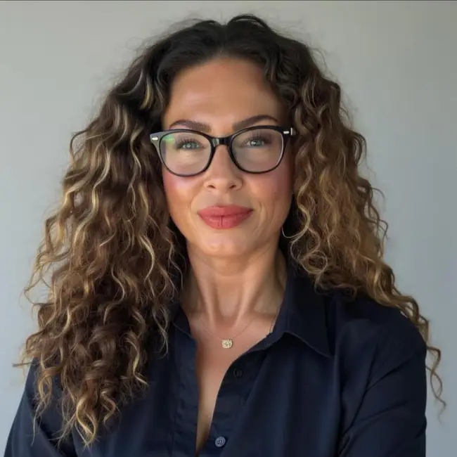 Practice Manager Stacy Hicks smiling while wearing glasses and a navy blouse - pet urgent response and emergency